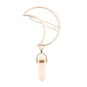 Detail of golden crescent moon hair clip with a pink hexagonal crystal pendant