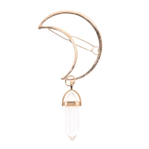 Detail of golden moon hair clip featuring a clear hexagonal crystal pendant drop