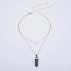 Detail of double-layer gold necklace with heart pendant and green hexagonal stone