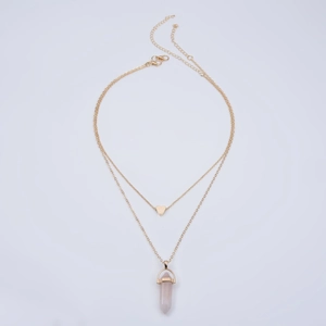 Detail of double-layer gold necklace with heart pendant and pink hexagonal crystal point