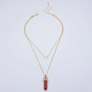 Detail of double-layer gold necklace with red hexagonal crystal and heart pendant