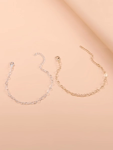Detailed view of interconnected heart chain bracelets in gold and silver with lobster clasps