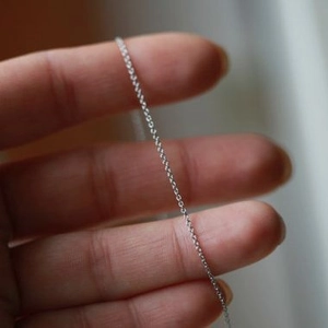 Zarte silberne Gliederkette im minimalistischen Stil auf der Hand zur Maßstabsanzeige
