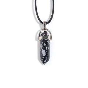 Macro shot of snowflake obsidian hexagonal column pendant with silver metal cap