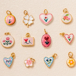 Détail de 12 breloques émaillées florales variées avec finition plaquée or 18 carats