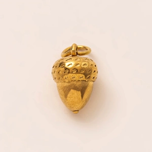 Detailed view of an 18K gold-plated stainless steel acorn pendant with textured cap