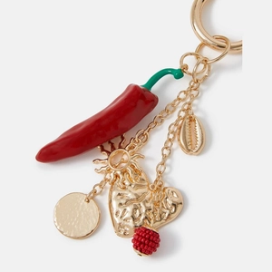 Macro detail of red enamel chili, golden heart and starfish pendants on a stylish keychain
