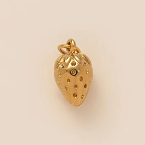 Macro detail of 18K gold-plated strawberry pendant with textured finish and dual rings