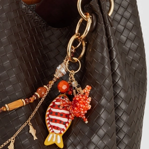 Detail of colorful beaded fish and starfish bag charm on a brown woven leather handle
