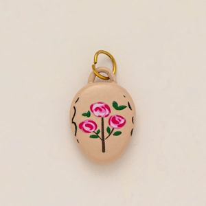 Detailed macro view of an egg-shaped strawberry jam pendant with pink rose motifs