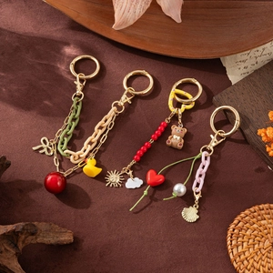 DIY creative keychains with colorful charms and beads on vintage textured background