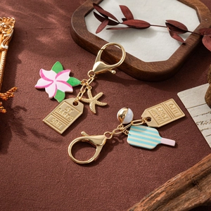 Enamel summer keychains featuring frangipani flower, starfish, and ice cream charms