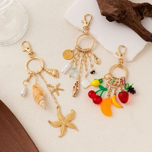 Three assorted 14K gold plated fashion keychains with sea, stone, and fruit charms