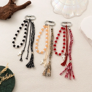 Bohemian bead tassel keychain with cross pendant and floral fabric fringe details