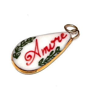 Détail d'un pendentif Amore en forme de goutte, émail blanc et bordure dorée