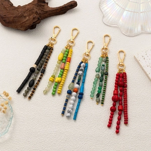 Detail of bohemian handmade beaded keychains with gold clasps in five diverse colors