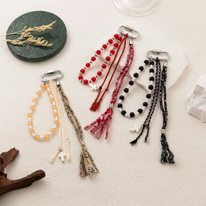 Close-up of bohemian beaded keychains with fabric tassels and white cross charms