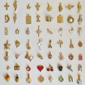 Verschiedene 18K vergoldete Edelstahl-Anhänger für DIY-Schmuck auf weißem Hintergrund