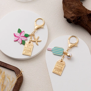 Detailed view of golden vacation keychains with tennis racket and starfish charms