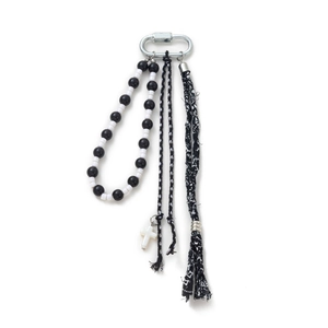 Detail of punk style keychain with black and white beads, metal carabiner and cross pendant
