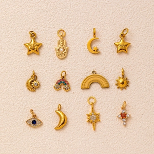Gros plan détaillé de 12 pendentifs dorés avec motifs soleil, étoile, lune et lucky