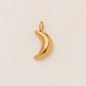 Détail macro d'un pendentif lune doré avec surface martelée texturée et anneau