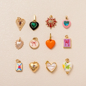Detailed grid of 12 mixed zircon and enamel heart pendants in gold metal finish
