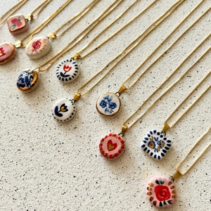 Vue détaillée de pendentifs en acier inoxydable plaqué or 18K avec motifs peints à la main
