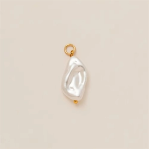 Macro shot of a baroque irregular pearl pendant with a golden loop and bead detail