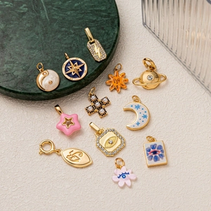 Detailed collection of gold plated charms with stars, moons, and enamel inlays on marble
