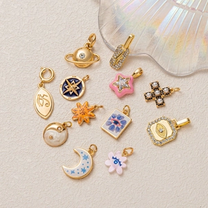 Golden stainless steel celestial charms set with planets, moons, and enamel stars