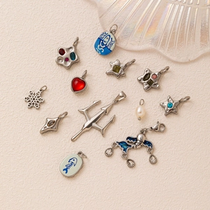 Close-up of mixed steel pendants including star, snowflake, and heart with colorful zircons