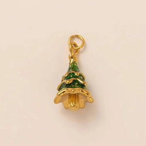 Detalle macro de un colgante de árbol de Navidad bañado en oro de 18K con esmalte verde