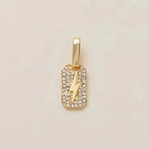 Macro view of gold-plated rectangular pendant with lightning bolt and white zircons