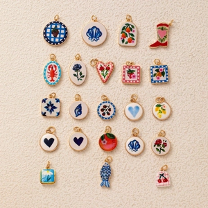 Macro shot of 22 pieces fruit and animal themed gold-plated enamel pendants set