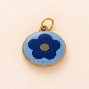 Makroaufnahme von blauem Emaille-Blumenanhänger mit vergoldeten Edelstahlkanten
