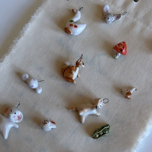 Handmade ceramic animal charms including swan and elephant with 18K gold plated metal rings