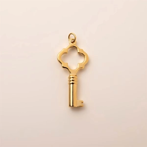 Macro view of 18K gold plated stainless steel key pendant with quatrefoil design
