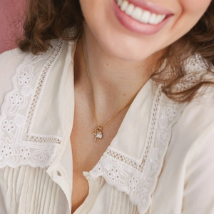 Exquisite gold pendant necklace featuring white pearl and zircon on a model