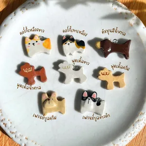 Detalle de varios colgantes de perro en cerámica en bandeja blanca con estilos Corgi