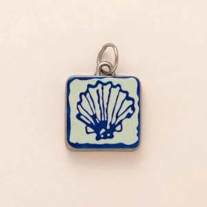 Macro detail of square stainless steel turtle pendant with shell motif in 18K gold