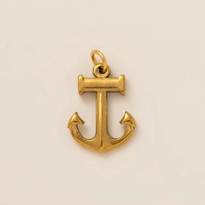 Macro view of vintage gold anchor pendant with fine matte texture and top hanging ring