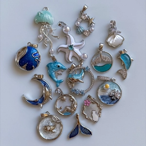 Collezione di ciondoli marini placcati in oro 18K con smalto blu e dettagli in madreperla