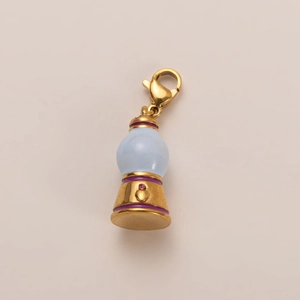 Macro detail of a 18K gold plated lamp pendant with blue sphere and red crystal inlay