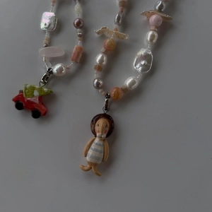 Detailed shot of beaded necklace with pearl, orange mineral stones and fun charms