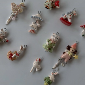 Macro shot of assorted ceramic animal pendants with hand-painted glaze and metal hooks