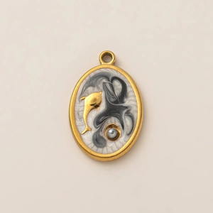 Détail d'un pendentif ovale plaqué or 18K avec texture marbre, dauphin et perle