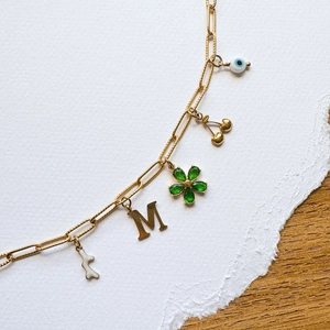 Collier à gros maillons dorés avec cinq pendentifs dont œil maléfique cerise et lettre M