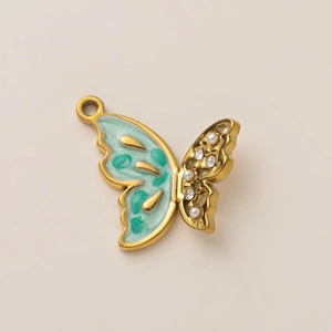 Vue détaillée d'un pendentif papillon doré 18K avec émail menthe et perles