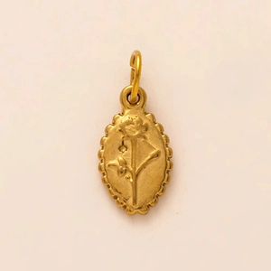 Détail d'un pendentif rose ovale doré en relief avec bords festonnés pour bijoux artisanaux